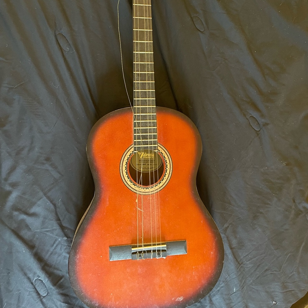 Valencia guitar that a 6 string three plastic and three metal strings.
